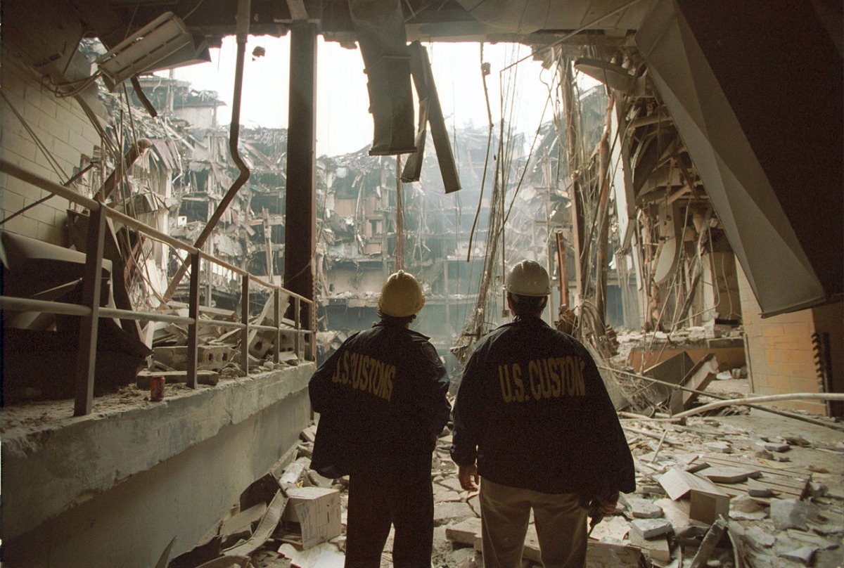 Two people viewing the interior of WTC 6, showing the massive vertical void extending through multiple floors